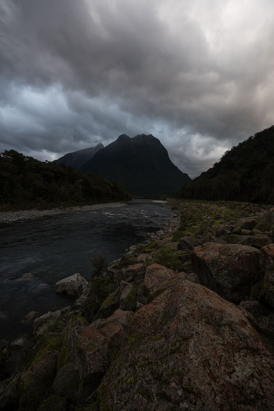 Cloudy mountain landscape with river underexposed
