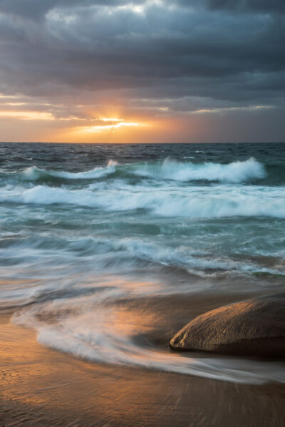 Morning waves at Blackwoods Beach reflecting the sunrise’s golden light in a peaceful ocean print scene.
