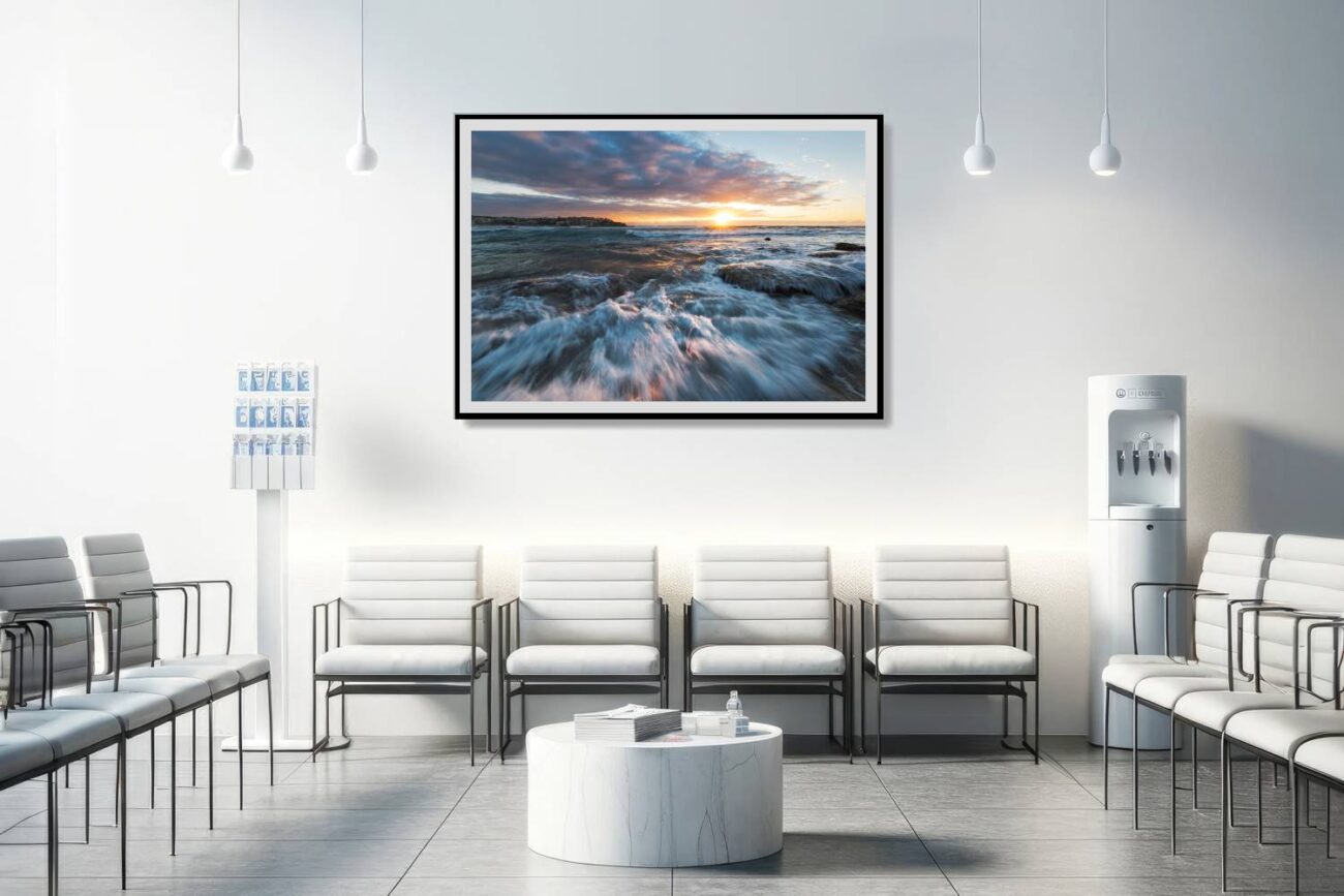 The medical office features a framed art print showcasing the sun's rays lighting up the playful waves at Bondi Beach. This lively and cheerful ocean scene contributes to a positive and invigorating atmosphere, aiding in creating a welcoming and uplifting environment for patients and staff.
