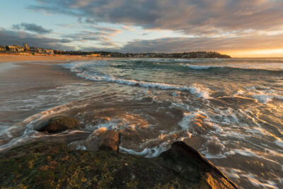 Sunrise at Bondi Beach with light playing on gentle waves, suitable for beach wall art or ocean art prints.