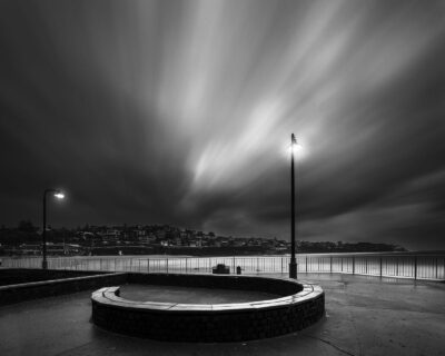 Long exposure photograph at Bronte Beach showing streaming clouds and a streetlamp, embodying "Time Flow" as black and white wall art.