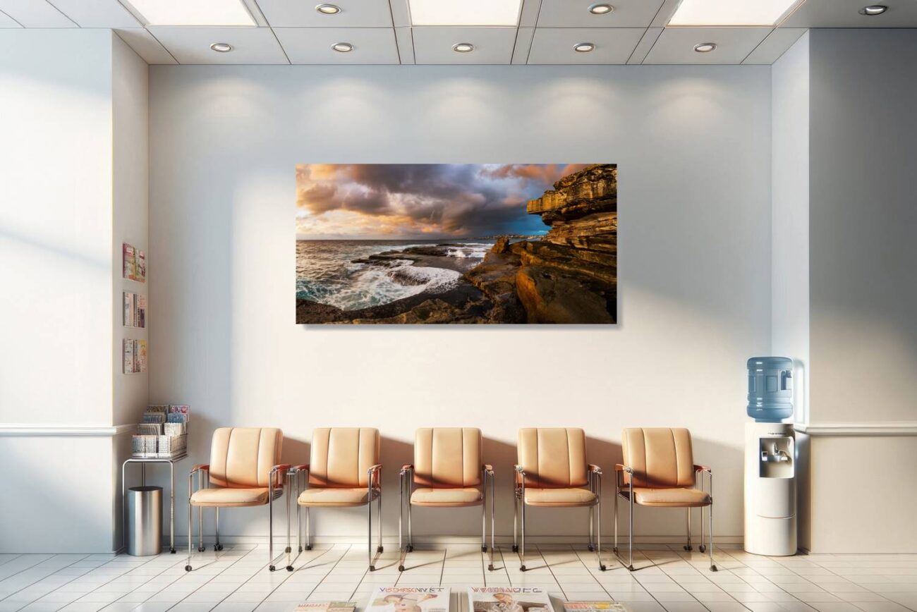 In the medical office, a framed art piece depicts the golden glow over the turbulent waves and rocky shores at Clovelly Beach, under a stormy sky. This artwork offers a sense of calmness and majesty, enhancing the therapeutic atmosphere and providing patients and staff with a visually soothing and thought-provoking scene.