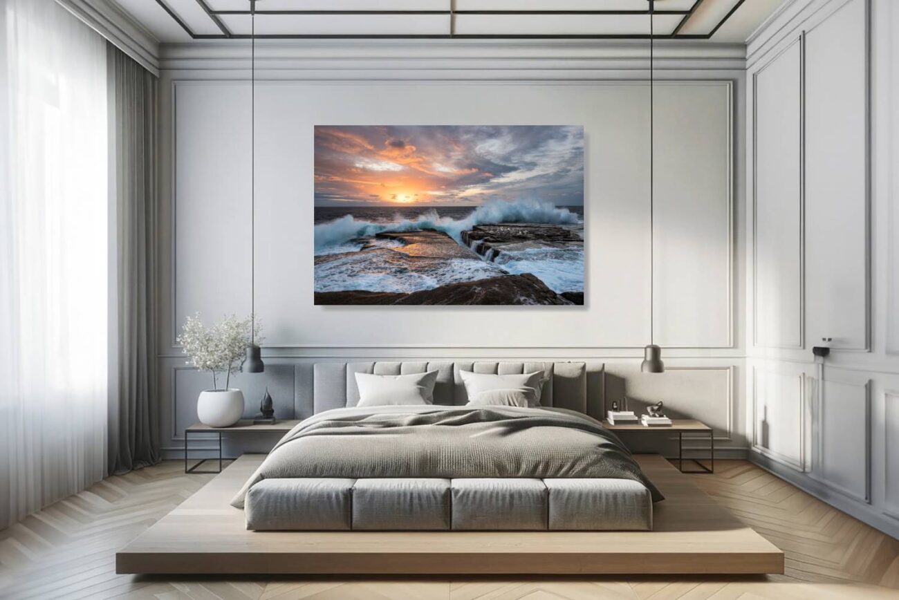 The bedroom's canvas art features "Dawn Chorus" at Clovelly Beach, depicting the sunrise and intense waves under a warmly lit sky. This piece brings the morning's vitality and warmth into the room, ideal for creating an uplifting and invigorating atmosphere.