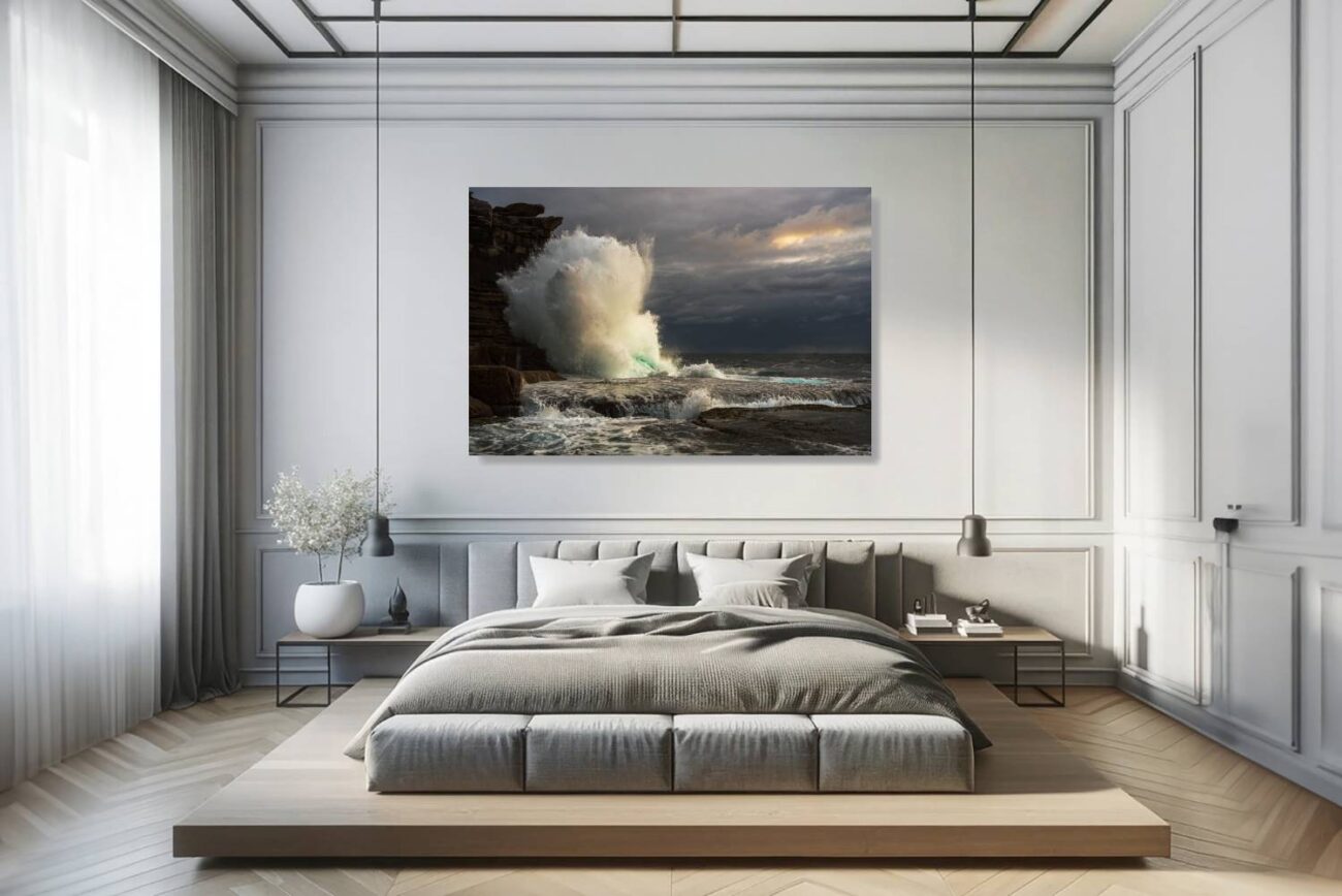 In the bedroom, canvas art depicts the dramatic scene of a massive wave crashing against Clovelly Beach's cliffs under stormy skies at sunrise. This artwork brings the awe-inspiring power of nature into the room, offering a dynamic yet peaceful backdrop for relaxation and reflection.