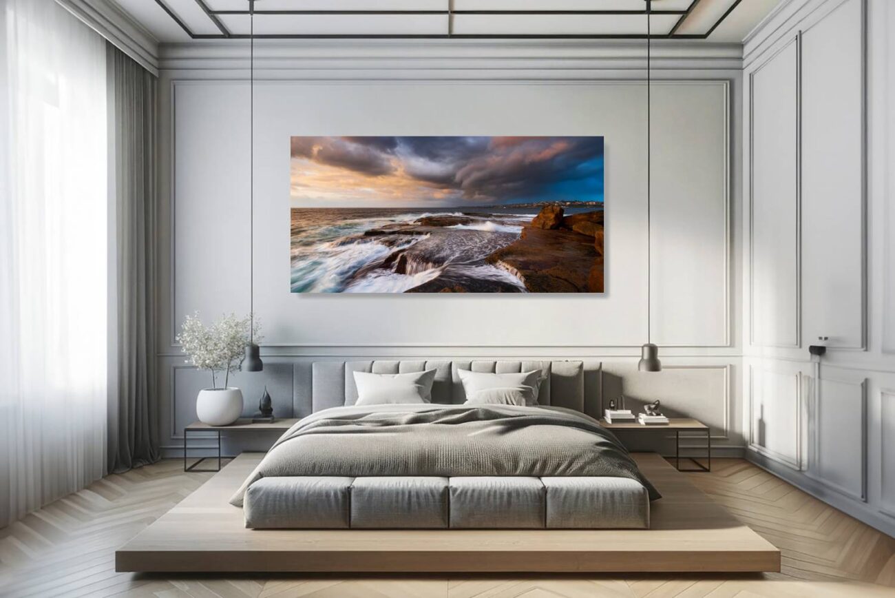 In the bedroom, "Indigo Fury" is displayed as canvas art, depicting the stirring scene of sunrise at Clovelly Beach with tumultuous skies and waves. This piece brings a sense of movement and raw natural beauty to the room, ideal for creating an environment that's both invigorating and contemplative.