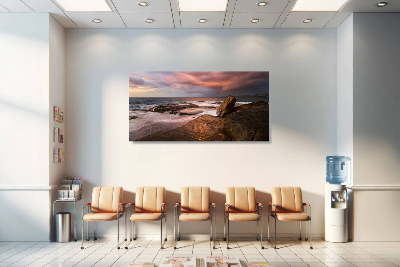 The medical office is adorned with a framed art piece depicting the dramatic sunrise at Clovelly Beach, with the storm clouds reflecting the sun's fiery hues against the calm sea. This powerful and serene scene contributes to a healing and uplifting environment, offering comfort and inspiration to patients and staff.