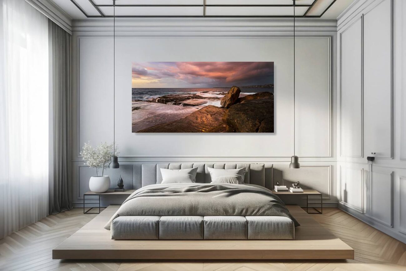 In the bedroom, canvas art captures the dramatic sunrise at Clovelly Beach, where the vibrant colors of the storm clouds contrast with the serene sea. This piece adds a touch of drama and natural beauty to the room, ideal for creating an atmosphere of reflection and inspiration.