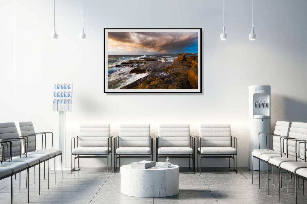 In the medical office, a framed art piece depicts the first light of day at Clovelly Beach, breaking through the storm clouds to highlight the dramatic dance of the ocean waves against the rocky shore. This captivating scene provides a soothing yet powerful backdrop, aiding in relaxation and offering patients and staff a moment of natural wonder.