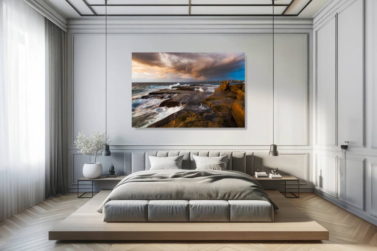 The bedroom's canvas art features the early light of day at Clovelly Beach, illuminating the storm clouds and casting a dramatic light on the interaction between the waves and the rocky shoreline. This piece brings a sense of majesty and introspection, ideal for creating a tranquil yet invigorating bedroom environment.