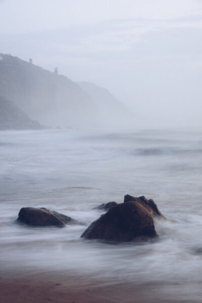 A misty morning at Coalcliff Beach with rocks shrouded in mystery, perfect for a serene ocean art piece.