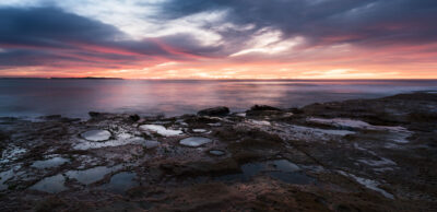 Sunset at Cronulla beach with vibrant pink and blue skies, evoking the quiet before a storm. Panoramic wall art.