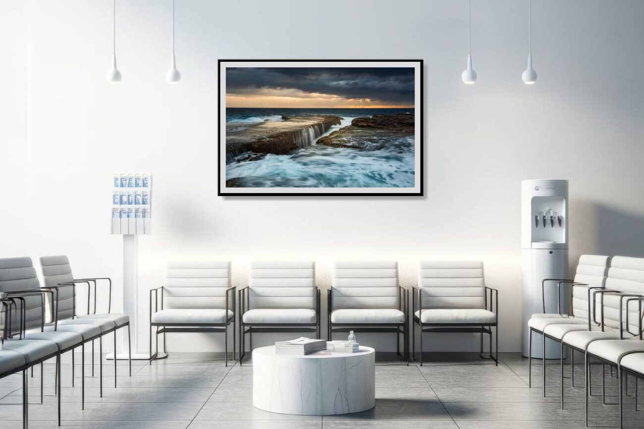 In the medical office, a framed art piece depicts the dynamic sunrise at Clovelly Beach, with waves that mimic waterfalls, suitable for storm artwork or elegant decor. This striking image provides a compelling focal point, enhancing the environment with its beauty and energy, aiding in creating an engaging and soothing space for patients and staff.