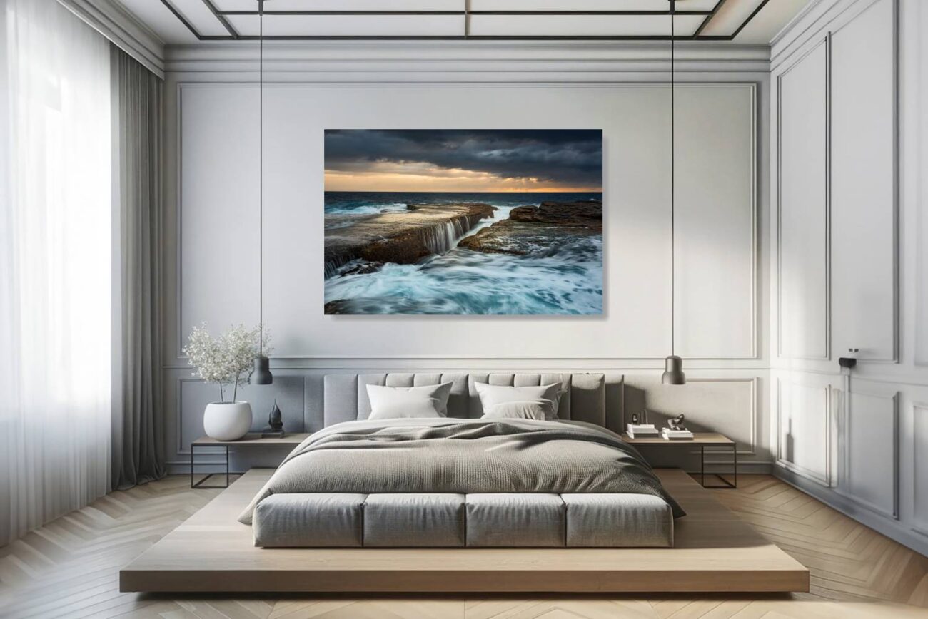The bedroom's canvas art features the vibrant scene of sunrise at Clovelly Beach, where the waves crash energetically, resembling waterfalls. This artwork brings the force and beauty of nature into the room, creating a lively yet elegant atmosphere conducive to inspiration and relaxation.