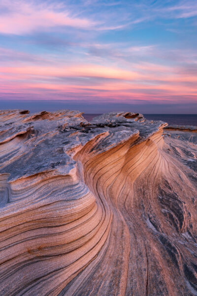 Soft sunset light over Potter Point’s wavelike sandstone formations.