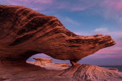 The sunset view through a sandstone archway at Potter Point creates an otherworldly vision.