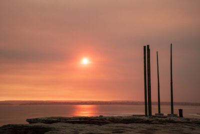 Bushfire smoke sunset at Potter Point with stark pillar silhouettes, a captivating scene.