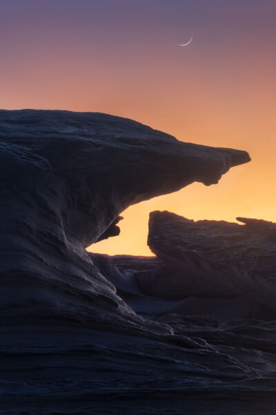 Sunset and crescent moon over silhouetted rock formations at Potter Point offer a visual escape.