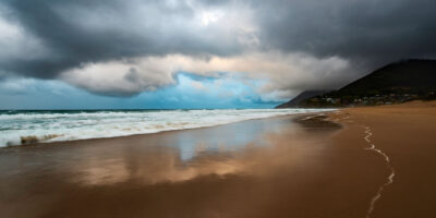 Calm center of a storm over Stanwell Beach, a moment of tranquility captured in ocean photography.