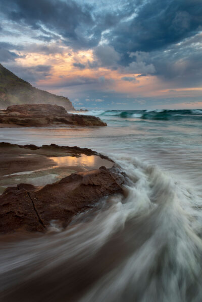 Sunset reflecting on tide pools with rushing waves at Stanwell Beach, a natural scene for ocean art prints.
