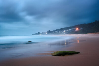 Early morning blue tones over Stanwell Beach with a moss-covered rock in the foreground for blue wall art.
