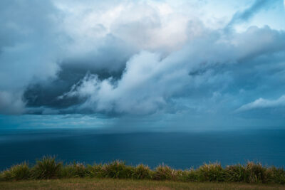 Dramatic clouds over the ocean at Stanwell Tops, captured in the blue wall art piece Facing Eternity.
