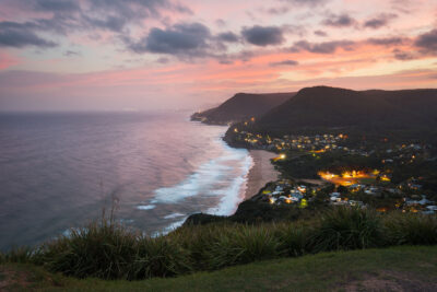 Sunset at Stanwell Tops with serene lavender and peach hues over a calm ocean.