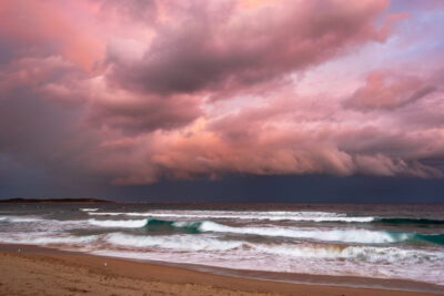 Sunset at Cronulla under a storm-painted sky, blending twilight hues for a dramatic ocean photography piece.