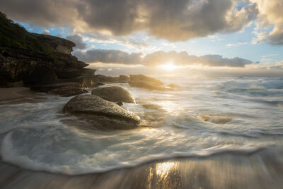 The sunrise at Tamarama Beach highlights the fluid artistry of the waves, capturing the tranquil essence of sea art.