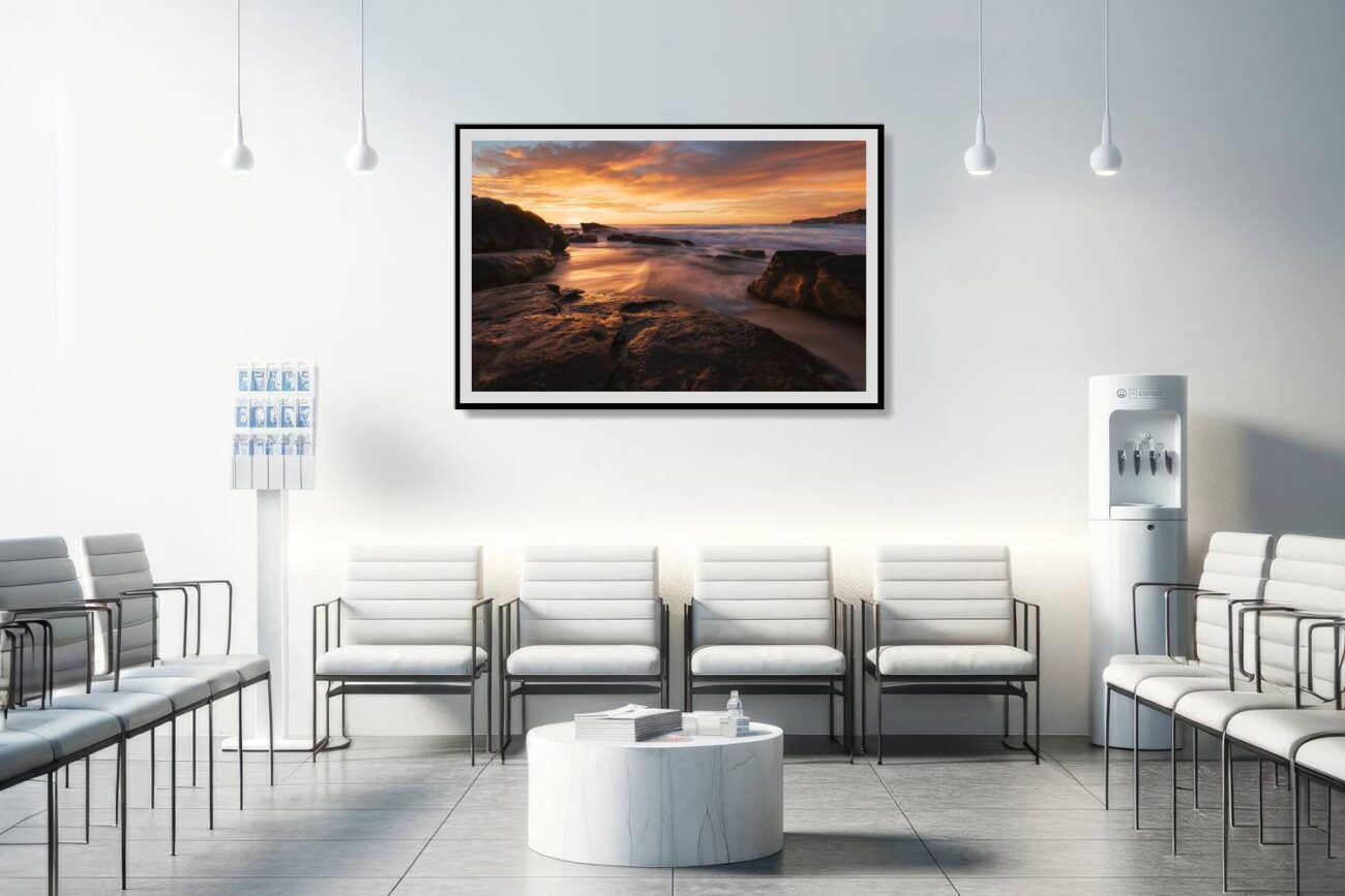 In the medical office, a framed piece of ocean artwork titled "Fiery Shores" displays the stunning sunset at Tamarama Beach. The illuminated waves and rocks create a soothing yet lively backdrop, aiding in the creation of a comforting and visually appealing environment for patients and staff.