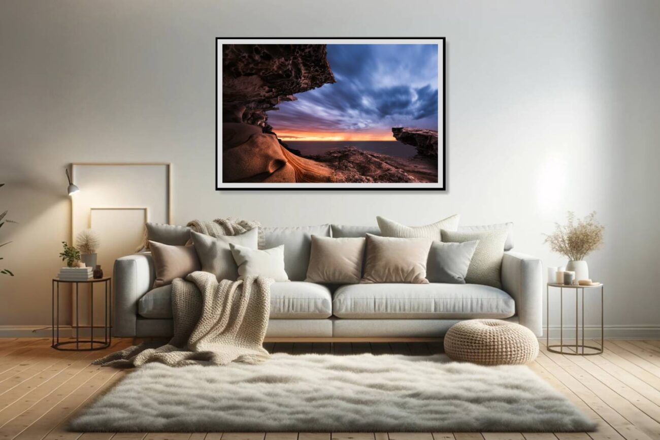 In the living room, a framed art piece captures the rock formation at Tamarama Beach framing the twilight sky, creating a natural portal between day and night. This artwork adds a mystical and contemplative element to the space, inviting viewers to explore the transition between light and darkness.
