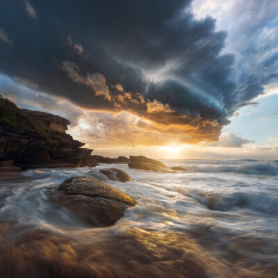 A sunrise storm at Tamarama Beach displays a vortex in the sky, a dramatic moment of sea art.