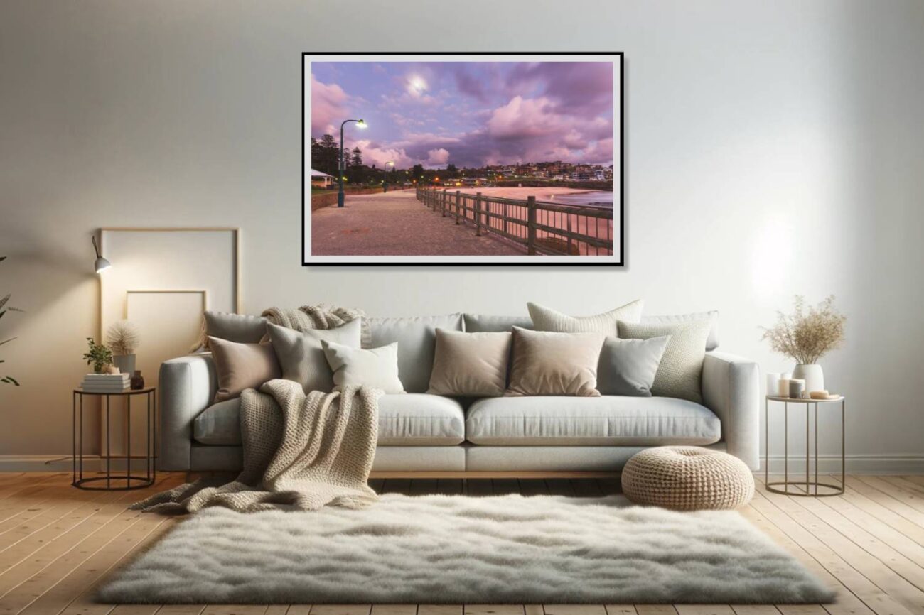 The living room features a framed art piece showcasing a pathway at Bronte Beach, illuminated by a streetlamp under a twilight sky adorned with purple and pink clouds. This artwork adds a touch of serene beauty and contemplation to the space, inviting viewers to appreciate the quiet moments of twilight.