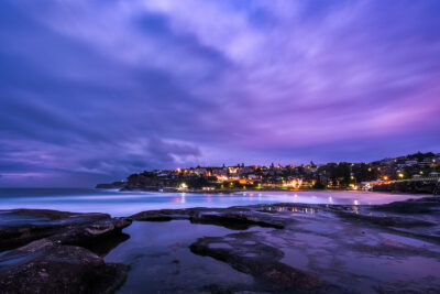 Violet and indigo hues of dusk reflected in the calm waters of Bronte Beach.
