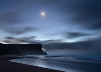 The tranquil beach under a moonlit sky at Garie Beach, captured in a serene night beach photography piece.