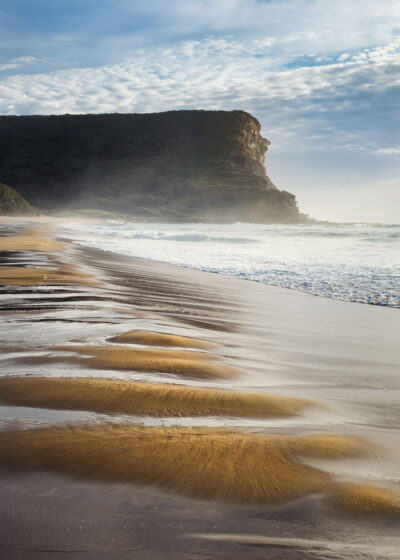 Morning light creating rhythmic patterns on the golden sands of Garie Beach, a serene piece of beach landscape.