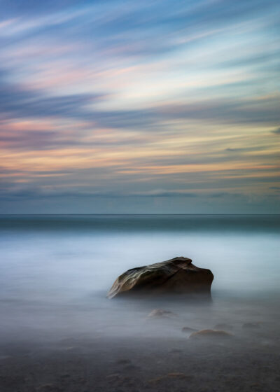 Peaceful sunrise at Werrong Beach with a lone rock amidst soft waves. Minimalist wall art.