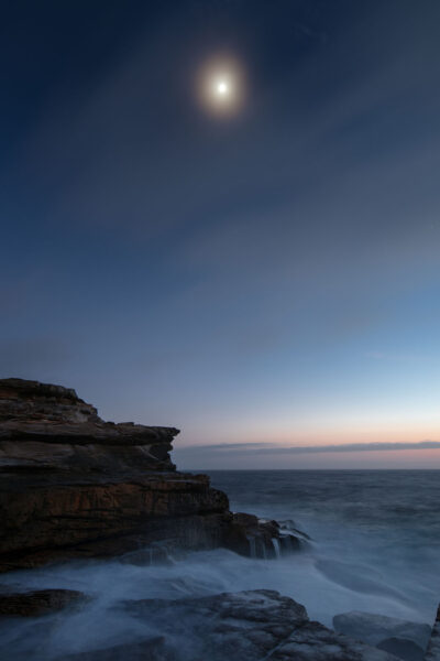 The tranquil scene at Mahon Pool before sunrise, with gentle moonlight casting a silver glow over the waters.