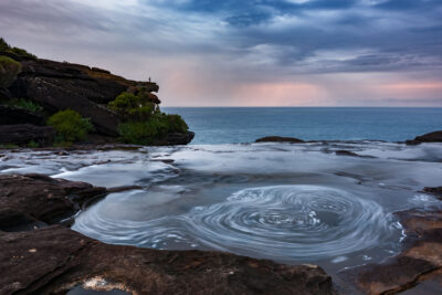 A twilight water vortex creates a compelling natural scene at the Royal National Park.
