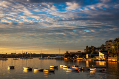 Sunset over Taren Point with boats illuminated in gold, creating a serene nature artwork.